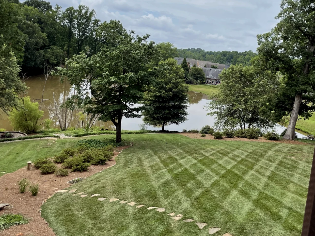 Lakeside lawn with professional mowing patterns in Winston-Salem, NC, serviced by GH Cutting Edge Lawn Mowing