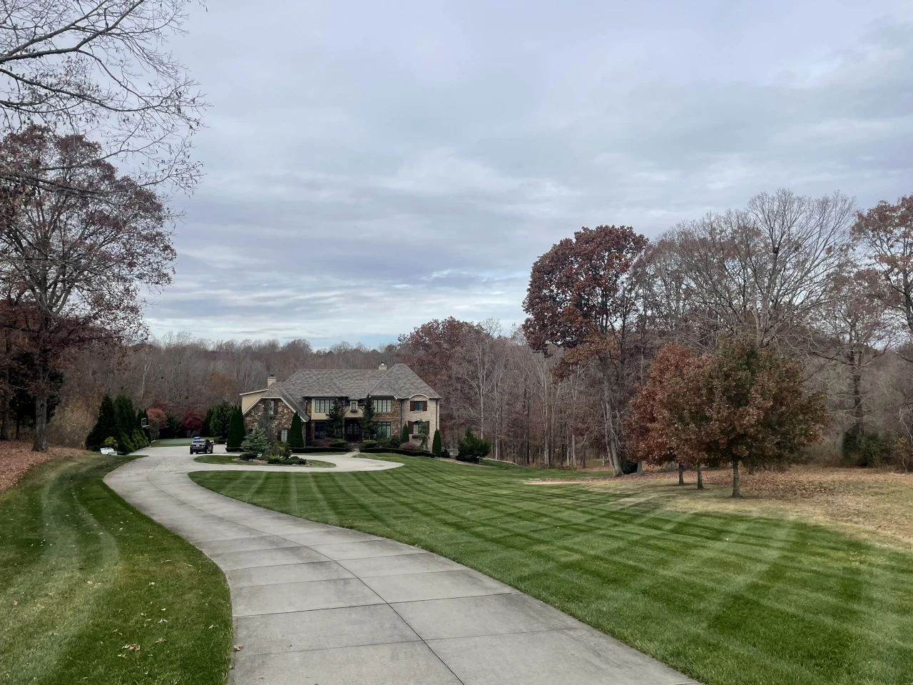 Estate lawn with professional striped mowing pattern in autumn in Winston-Salem, NC by GH Cutting Edge Lawn Care