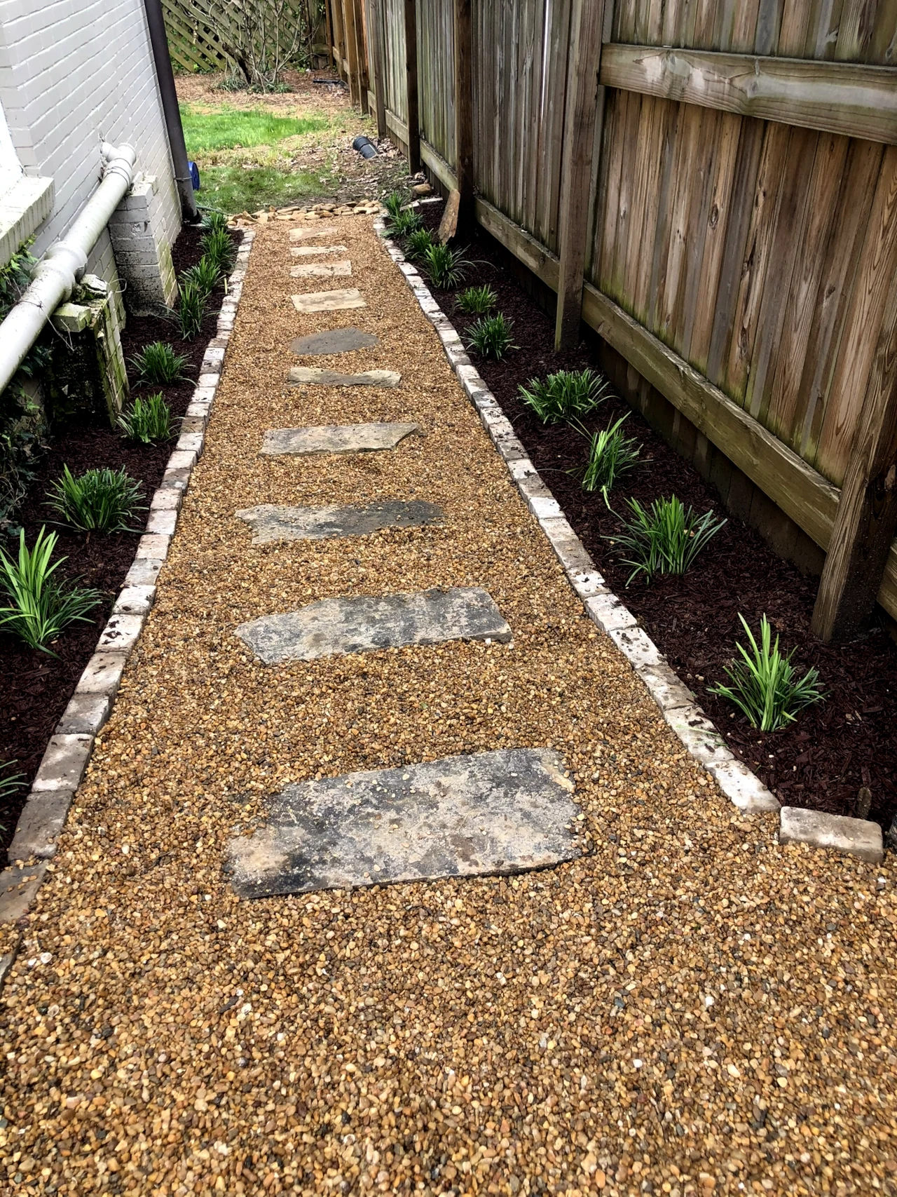 Newly installed garden pathway with stepping stones and landscaped borders by GH Cutting Edge Hardscapes in Winston-Salem, NC