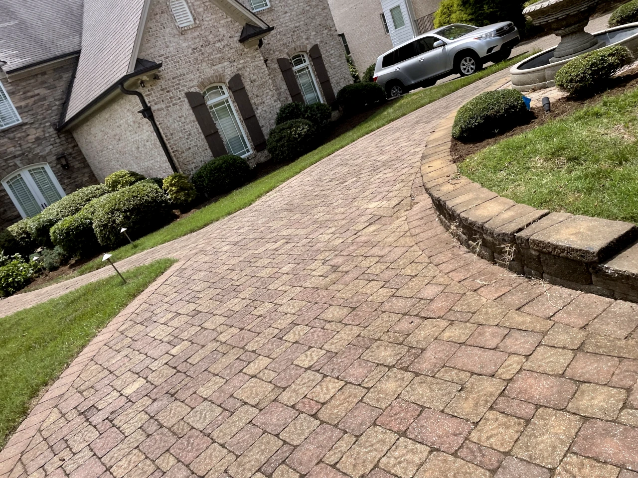 Luxurious brick driveway with curved hardscape design in Winston-Salem, NC by GH Cutting Edge Hardscapes