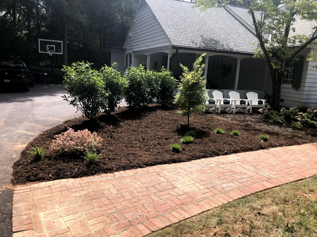 Professionally landscaped garden with brick walkway and seating area installed by GH Cutting Edge Hardscapes in Winston-Salem, NC